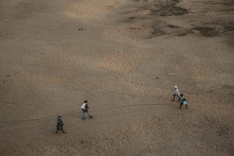 Des habitants traversent le lit de la rivière Mandrare, près d'Amboasary. Le cours d'eau est souvent à sec entre les mois d'avril et d'octobre. Madagascar, septembre 2021.
 © RIJASOLO / AFP