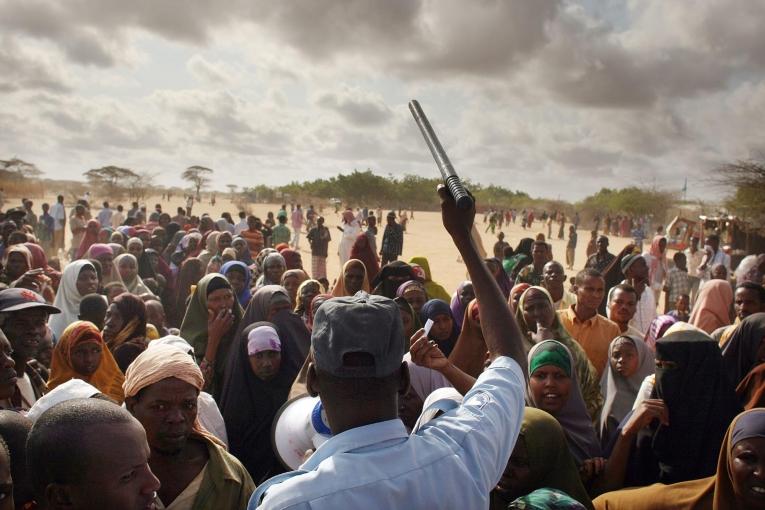 Un officier de sécurité ordonne à des centaines de personnes désespérées de se rendre dans un camp de réfugié moins peuplé. Août 2009. Dadaab, Kenya.
 © Spencer Platt