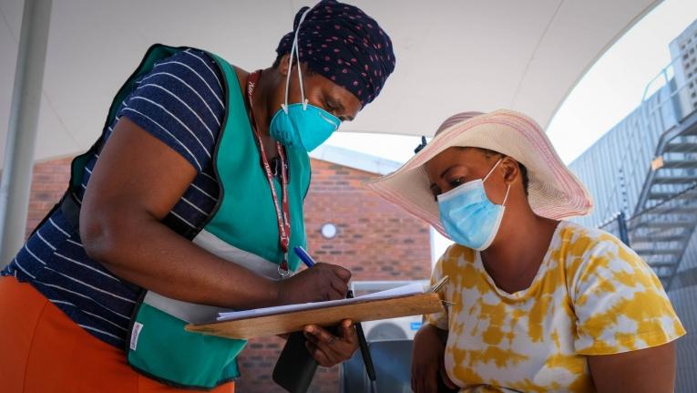 Une membre des équipes de promotion de la santé MSF aide une patiente à s'enregistrer pour la vaccination Covid-19 dans une clinique de&nbsp;Khayelitsha. Afrique du Sud.

&nbsp;
 © MSF