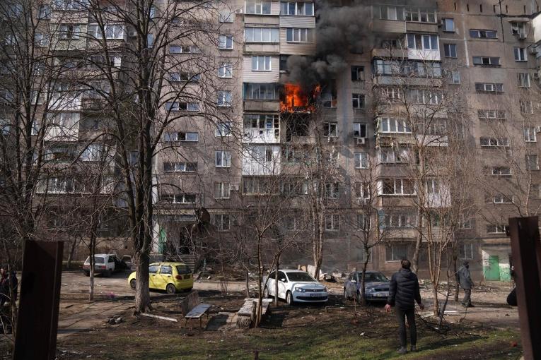 Des personnes regardent un appartement brûler après un bombardement à Marioupol. Ukraine. 13 mars 2022.&nbsp;
 © Evgeniy Maloletka/AP Photo