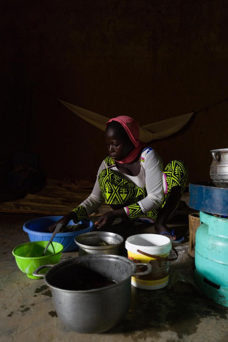 Bria prépare les repas de ses enfants à la maison, quelques jours après la sortie de Séverin de l'hôpital pour malnutrition aiguë sévère.
 © Lys Arango