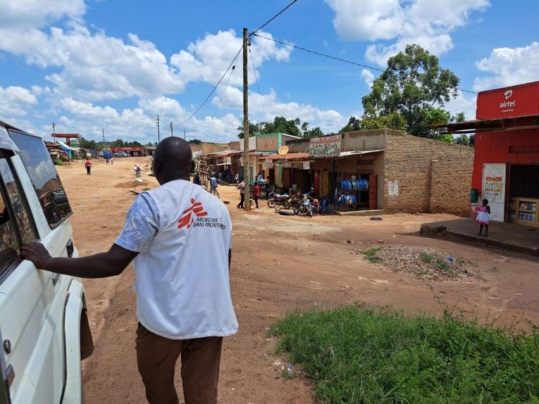 Un membre des équipes MSF de promotion de la santé attend ses collègues qui informe les habitants d'un village sur les risques liés à Ebola. Ouganda. 2022.
 © MSF/Sam Taylor