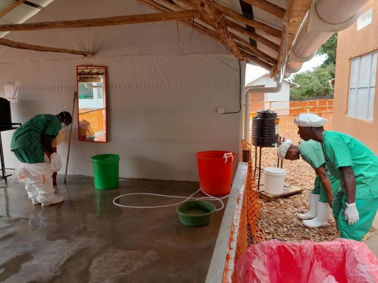 Un infirmier MSF retire sa tenue de protection individuelle après avoir effectué des soins sur des patients, dans le centre de traitement de Mubende. Ouganda. 2022.
 © Sam Taylor/MSF