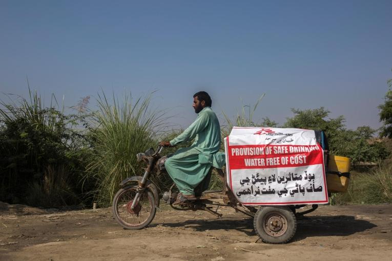 Muhammad Shareef, travailleur watsan, transporte des bidons d'eau qu'il a remplis pour fournir les camps de Garhi Khairo et Tehsil du district de Jacobabad,&nbsp;dans la province du Sindh au Pakistan le 28 octobre 2022.
 © Asim Hafeez