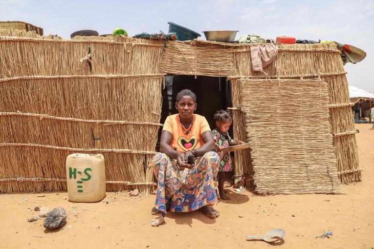 Safi 30 ans, maman de 5 enfants, (ici avec sa plus jeune fille) , originaire du village de Yalanga devant sa case à Djibo.
 © MSF/Nisma Leboul