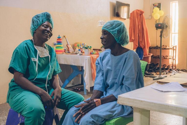 Une patiente touchée par le noma, en discussion avec une conseillère MSF à l'hôpital de Sokoto. Nigeria. 2023.
 © Fabrice Caterini/Inediz