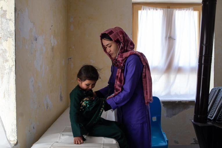 Une sage-femme MSF ausculte une fille de six ans qui souffre de la teigne et de malnutrition, dans le centre de santé de Jalmish, soutenu par MSF. Afghanistan.
 © Nava Jamshidi