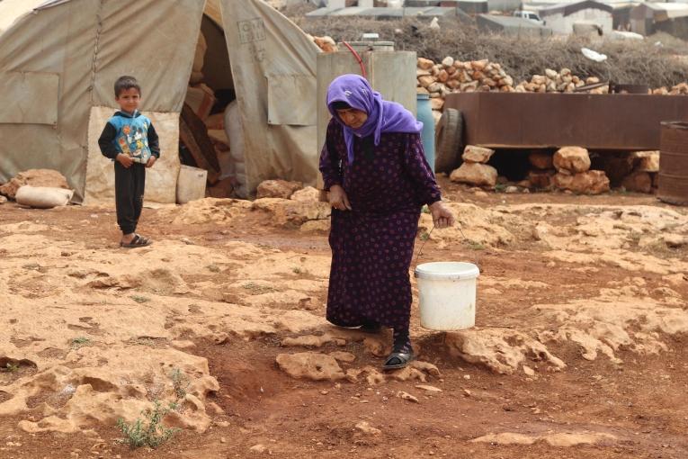 Une femme et un enfant dans un camp de déplacés du nord-ouest de la Syrie. L'accès à l'eau et à l'hygiène est problématique pour ces populations. 2023.
 © MSF