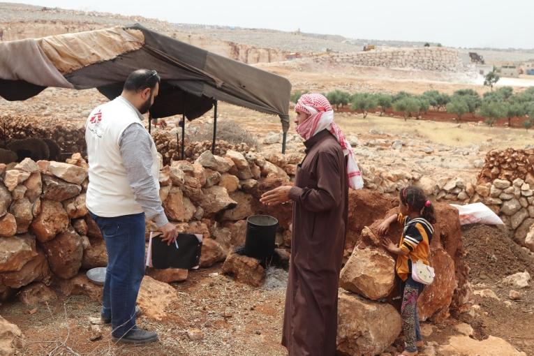 Un membre des équipes MSF en discussion avec le responsable d'un camp de déplacés du nord-ouest de la Syrie. 2023.
 © MSF