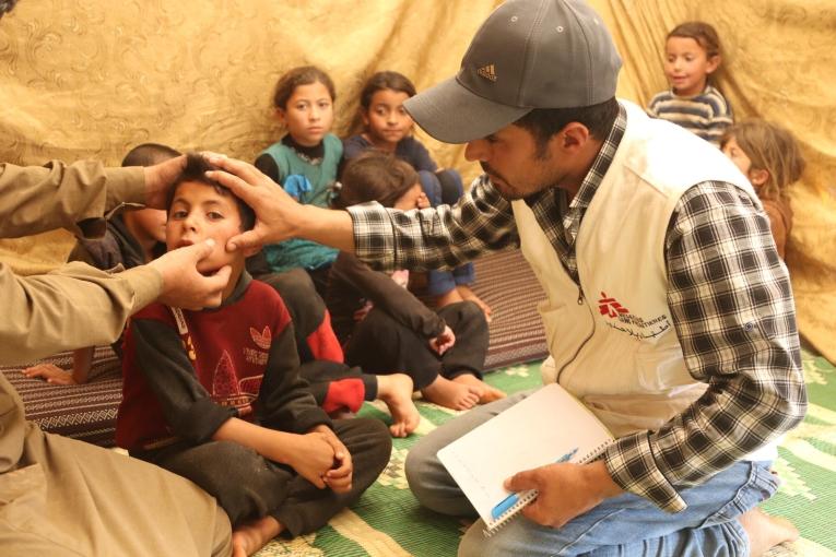 Une membre des équipes MSF avec un jeune patient atteint de leishmaniose, dans un camp de déplacés du nord-ouest de la Syrie. 2023.
 © MSF