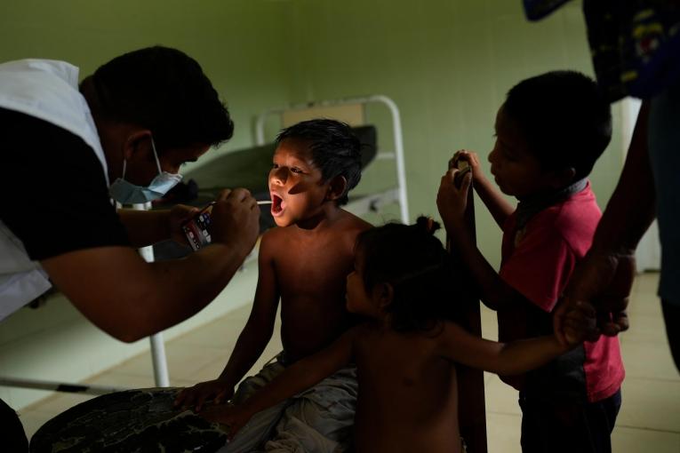 Une enfant souffrant de fièvre en consultation avec un membre des équipe MSF. Elle a voyagé plusieurs heures en bateau avec sa famille pour se rendre à Nabasanuka et recevoir des soins. Venezuela. 2023.
 © Matias Delacroix