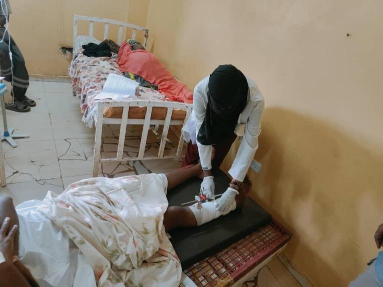 Un membre du personnel médical termine le pansement d'un patient à l'hôpital&nbsp;Al Nao, au Soudan.
 © MSF