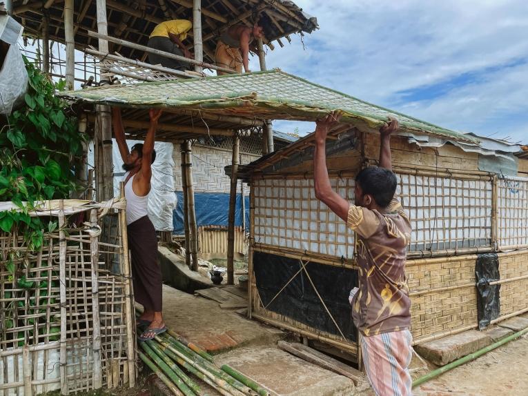 Un groupe de personnes transportant des matériaux de construction dans les camps.&nbsp;
 © Victor Caringal/MSF