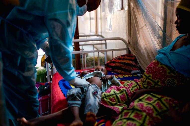 Un enfant en consultation avec un médecin du centre de traitement de Siguiri. Décembre 2023. Guinée.
 © MSF/Andrej Ivanov