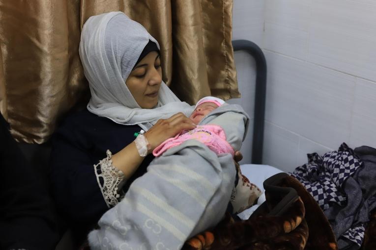 Une mère tient son enfant dans ses bras à l'hôpital émirati de Gaza.
 © Mariam Abu Dagga/MSF