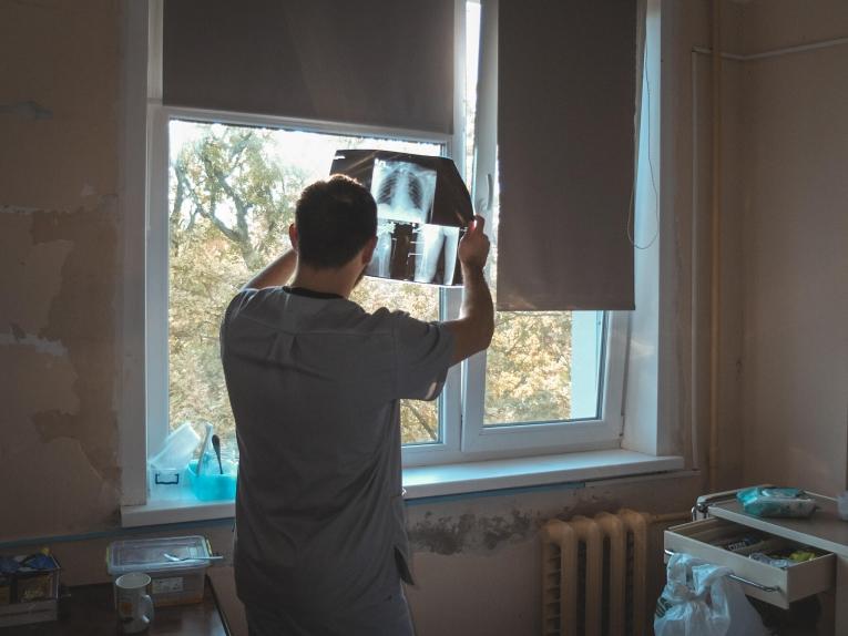 Le physiothérapeute MSF Oleksii Taranenko examine les radios d'un patient avant une séance thérapeutique. Octobre 2024.
© Anhelina Shchors/MSF