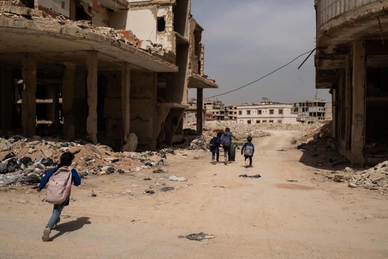 Des enfants jouent avec un pneu de voiture après la sortie de l'école, alors qu'ils rentrent chez eux dans l'une des rues de Daraya.
 © Al Baraa Haddad/MSF