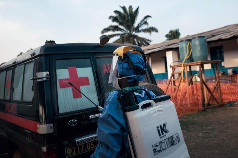 Un agent d'hygiène du centre de traitement Ebola géré par MSF désinfecte les portes d'une ambulance après le transport d'un patient suspecté d'être atteint de la maladie à virus Ebola.
 © Alexis Huguet/MSF