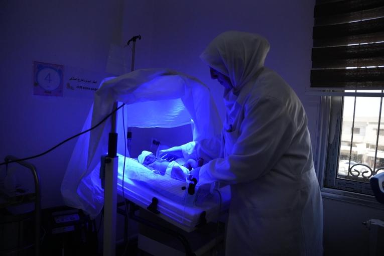 Une infirmière de la Direction de la santé soigne un nouveau-né dans le service de néonatologie de l'hôpital national de Nawa, où MSF soutient les services de néonatologie.
 © Oday Alshobaki/MSF