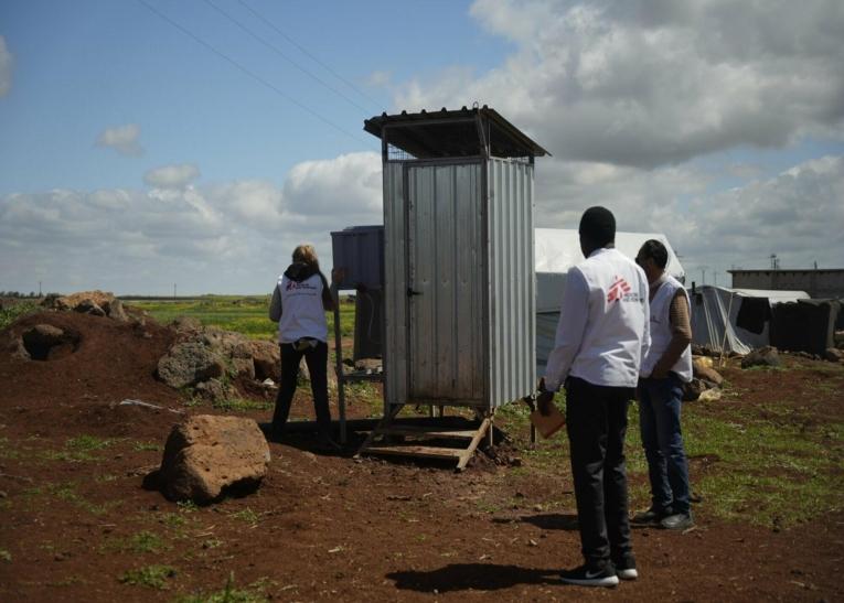 Une équipe de MSF vérifie des latrines installées pour les personnes déplacées dans une zone rurale de Daraa.
 © MSF