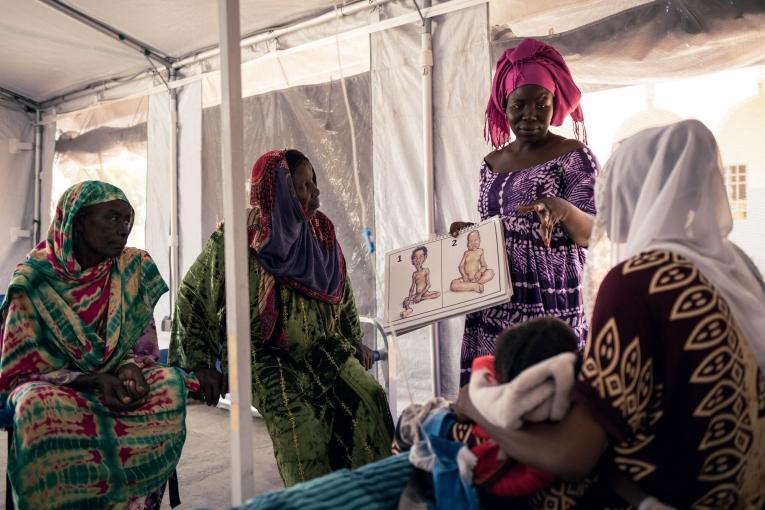 Gakéné Warmaï, a health promoter, talks with Khadidja Issaka, 20, and her daughter Maïmouna Ibrahim, 2.5, who has been admitted to the measles isolation unit supported by MSF and is also being treated for malnutrition at the Am Timan Hospital.
 © Alexis Huguet/MSF