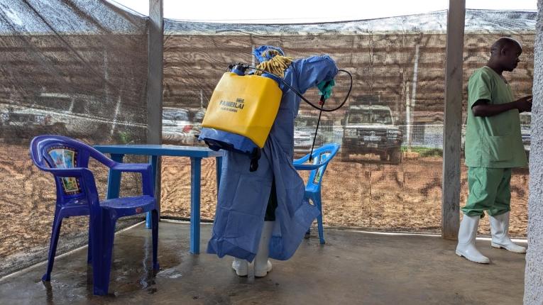 Un hygiéniste travaille à la décontamination préventive des parties communes dans le centre de traitement Ebola de Kitatumba.&nbsp;
 © Augustin Mudiayi/MSF