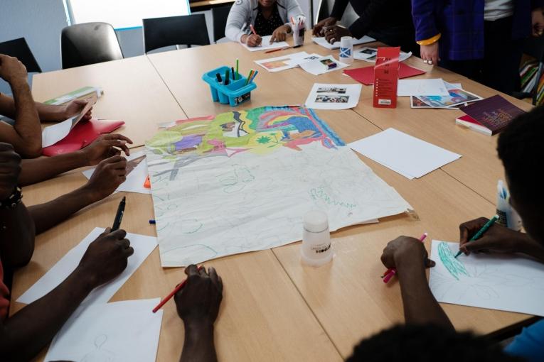 Des jeunes participent à des cours de sensibilisation à l'art et des cours d'art plastique dans la salle d'activité de l'hôtel MSF organisés par une bénévole qui travaillent au Musée d'art contemporain de Paris. 2018. France.