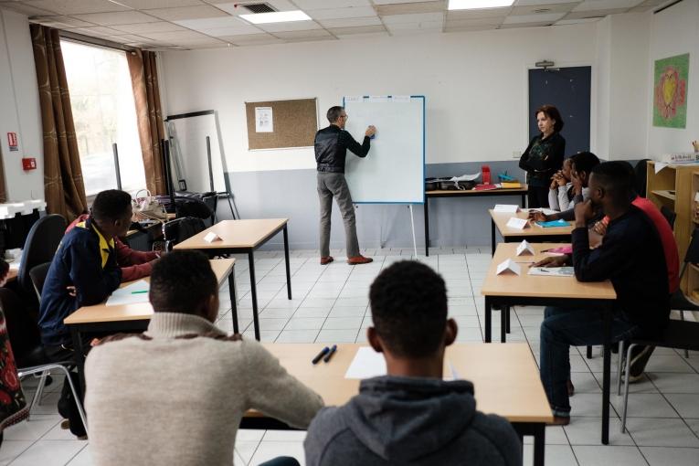 Des cours de français sont organisés par des professeurs bénévoles pour aider les jeunes à perfectionner leur niveau de langue, dans une salle d’activité de l’hôtel Passerelle de MSF. 2018. France.