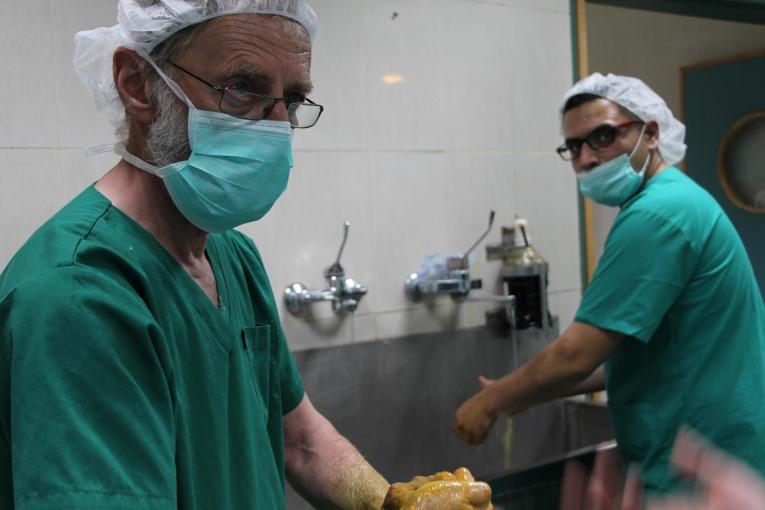 un chirurgien vasculaire de MSF et un infirmer de bloc opératoire procèdent au lavage chirurgical des mains avant d’entrée en salle d’opération. Palestine. 2018. Thumbnail