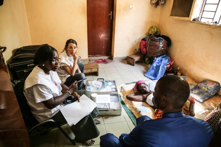 Le Dr. Djénabou Diallo et l'infirmière Nathalie Kornfein en discussion avec une patiente et sa famille à leur domicile. Bamby a 77 ans et elle est atteinte d'un cancer du sein. Les échanges sont importants dans les soins de supports et palliatifs, notamment pour répondre aux nombreuses questions concernant l'état du patient. Mali. 2019.