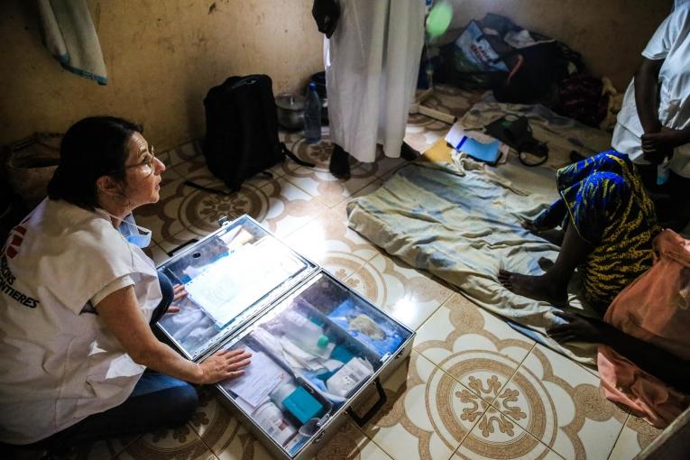 L'infirmière MSF Nathalie Kornfein au domicile d'une patiente âgée de 40 ans, atteinte d'un cancer du sein. Les visites à domicile ont lieu plusieurs fois par semaine et permettent notamment de surveiller l'état des plaies tumorales des patients. Mali. 2019.