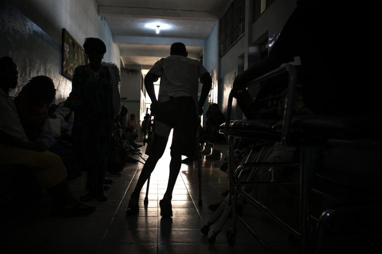 Un patient avec des béquilles quitte le couloir de consultation ambulatoire de Bamenda.