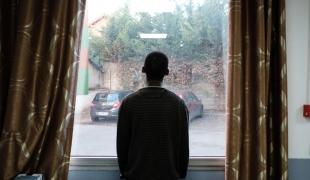 Un jeune bénéficiaire du projet MSF Passerelle regarde par la fenêtre depuis l’hôtel. 2018. France.