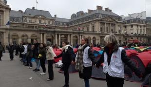 Des membres d'associations forment une chaîne de protection humaine devant le Conseil d'État à Paris lors d'une action pour alerter sur la situation des jeunes étrangers, le 2 décembre 2022