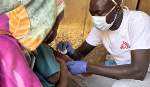 Salah Aldeen, infirmier de MSF, pose une perfusion intraveineuse à Marwa, 3 ans, admise car elle présentait les symptômes de la rougeole. Nord du Jebel Marra, Soudan, mai 2025. 
