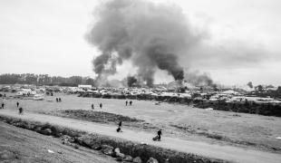 Vue d'ensemble sur un campement de fortune à la frontière franco-britannique. La fumée la violence dans ces camps.