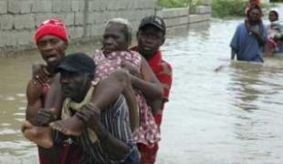 Des Haïtiens traversent une rivière après qu'une série de tempêtes se soit abbatue sur l'île.