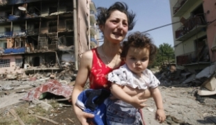 Géorgienne et son enfant fuyant leur maison détruiteà Gori le 10/08/2008