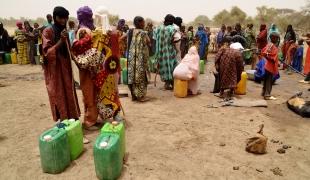 Attente devant un point d'eau dans le camp de Férrerio au Burkina Faso.