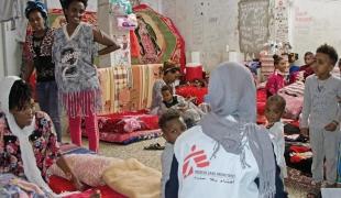 Un membre des équipes MSF échange avec un groupe de femmes et d’enfants détenus dans le centre de Khoms. 50 femmes et enfants se trouvaient dans cette cellule, les détenus hommes étaient dans une autre cellule.  Libye. 2018.