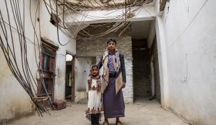 Les enfants de la famille Ghani posent devant l'entrée de leur maison, bombardée pendant la guerre de Saada, entre 2004 et 2010. Haydan. Yémen. mars 2018.