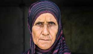 Rasmiyya a 63 ans. Elle habite seule dans le camp de déplacés de Amriya Falloujah depuis 2016. Elle a perdu quatre de ses sept enfants en 2004 lors du bombardement de sa maison dans la ville de Falloujah par l'armée américaine. Un autre de ses enfants est en prison depuis 2006. Irak. 2018.