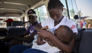 Aida Joao, travailleuse communautaire MSF, évacue un enfant suspecté d'être atteint de pneumonie d'un bidonville de Beira, où MS effectue des cliniques mobiles depuis le cyclone Idai. Mozambique, 26 mars 2019.