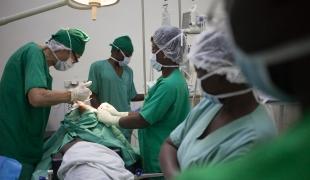 Un chirurgien de l'hôpital MSF SICA à Bangui tente d'extraire une balle profondément logée dans l'épaule d'un patient. Avril 2018. République centrafricaine. 