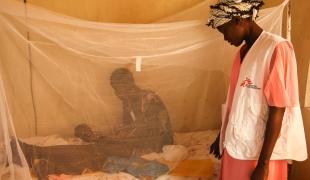 Elizabeth, traductrice médicale de MSF, se tient debout à côté du lit d’une jeune mère dans la maternité de l’hôpital MSF d’Ulang, au Soudan du Sud.