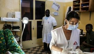 Nathalie Kornfein, infirmière MSF, fournit des soins à une patiente âgée de 76 ans, à l'Hôpital Universitaire du Point G à Bamako. La patiente vivait dans la région de Kayes mais a dû déménager à Bamako pour accéder aux soins oncologiques. Seuls les hôpitaux de la capitale en fournissent. Mali, le 4 septembre 2019.