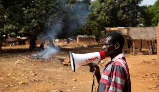 Un travailleur communautaire MSF annonce l'heure et le lieu d'une vaccination. République centrafricaine. 2020. 