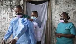 L’épidémiologiste Gaston forme et aide le personnel local du centre de santé Le Temps d’un Soir de Mbandaka à enfiler les équipements de protection donnés par MSF pour améliorer la protection et le contrôle des infections dans ce centre de santé qui a connu 8 cas confirmés Ebola au début de l’épidémie. Mbandaka, Equateur, RDC, 27 octobre 2020.