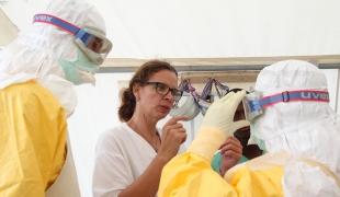 Anja Wolz aide ses collègues à enfiler un kit de protection Ebola lors de la grande épidémie qui a frappé l'Afrique de l’Ouest en 2014-2016.