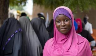 Dans le centre du Mali, une jeune fille attend pour une consultation devant le centre de santé MSF de son village, où des personnes fuyant les combats se sont réfugiées. 